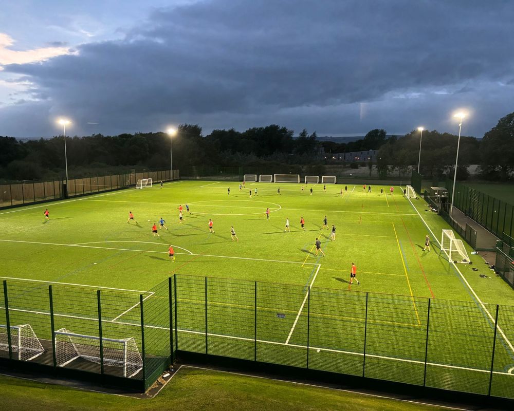 Artificial grass pitch at Humberston Park Academy at nighttime under floodlights.